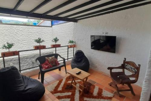 a living room with a couch and chairs and a tv at Casatoca House Zapatoca Lengerke in Zapatoca