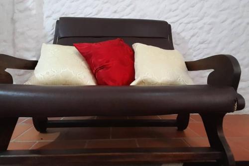 a black leather couch with three pillows on it at Casatoca House Zapatoca Lengerke in Zapatoca