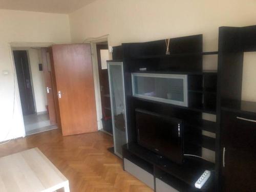 a living room with a black entertainment center with a microwave at Amazing Apartments in Bucharest