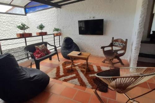 a living room with furniture and a flat screen tv at Casatoca House Zapatoca Lengerke in Zapatoca