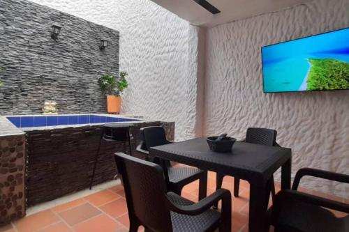 a kitchen with a table and a tv on a wall at Casatoca House Zapatoca Lengerke in Zapatoca