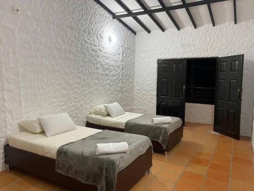 two beds sitting in a room with at Casatoca House Zapatoca Lengerke in Zapatoca