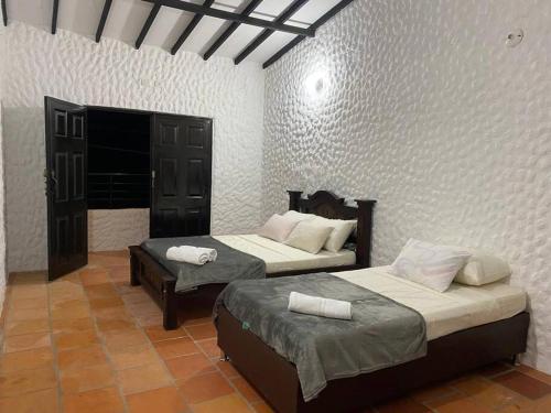 a room with two beds in a room at Casatoca House Zapatoca Lengerke in Zapatoca