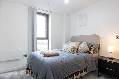 Schlafzimmer mit einem Bett und einem großen Fenster in der Unterkunft Long term rental in Man City in Manchester