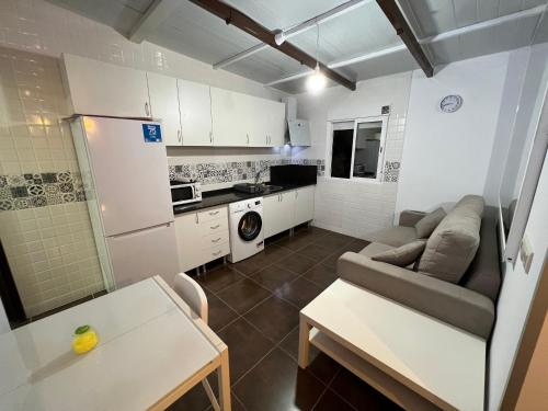 a small kitchen and living room with a couch and a table at Casa Elsa Ceuta in Ceuta