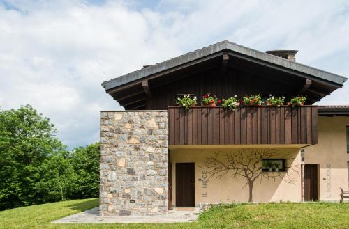 a house with a balcony with flowers on it at Quader nidi nel verde in Bienno