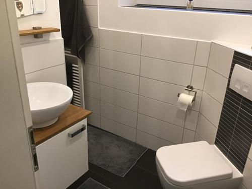 a bathroom with a white sink and a toilet at Moderne private Monteurs- und Ferienwohnung in Geesthacht