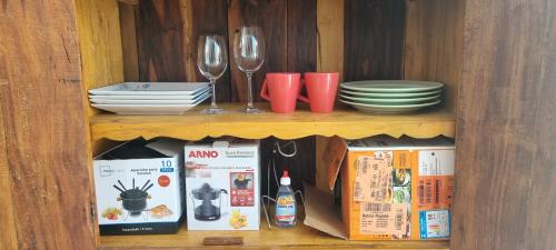 a wooden cabinet with plates and wine glasses at Casa Familiar Moradas Pelotas in Pelotas