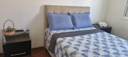 a bedroom with a bed with a blue and white comforter at Casa Familiar Moradas Pelotas in Pelotas