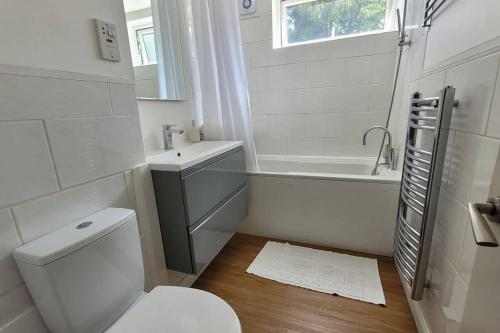 a white bathroom with a toilet and a sink at Antoni's Apartment in London