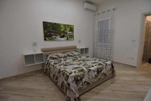 a bed in a bedroom with a painting on the wall at Casa Romeo in Lecce