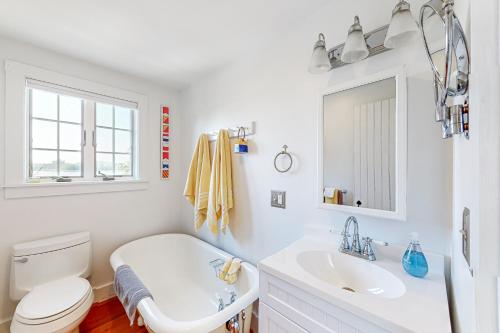 a white bathroom with a toilet and a sink at Topgallant in Wiscasset