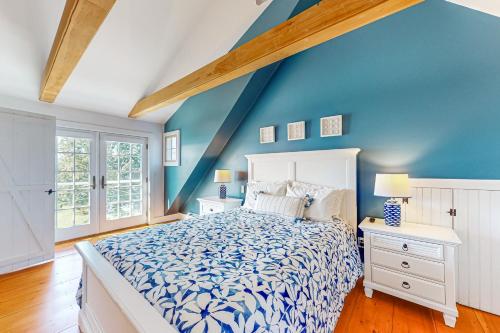 Dormitorio azul con cama blanca y paredes azules en Topgallant en Wiscasset