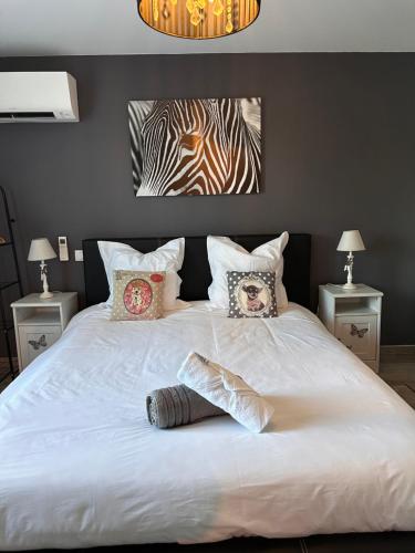 1 dormitorio con 1 cama blanca grande con almohadas en Gite La Licorne, en Entrechaux