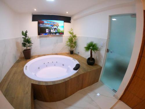 uma casa de banho com banheira e chuveiro em TH 101 - Flat com Banheira de Hidromassagem em Governador Valadares