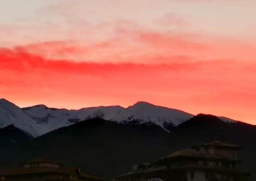 a sunset with mountains and a red sky at Spa Luxury Homes Banya in Banya
