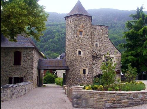 een groot stenen gebouw met een toren erop bij Appartement Cosy au cœur de Saint Lary in Saint-Lary-Soulan
