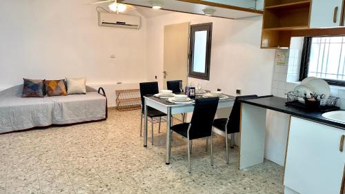 a kitchen and a living room with a table and chairs at Salamandra Guest House מקלט פרטי in Nahariyya