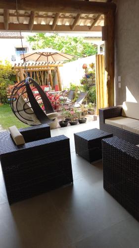 a porch with chairs and a hammock on a patio at Pousada Vila Mar in Itaúnas