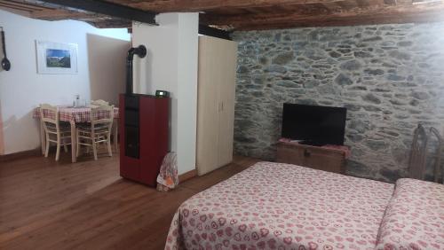 a bedroom with a bed and a stone wall at Maison 1940 La Bethaz in Valgrisenche