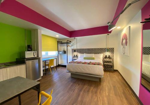 a bedroom with a bed and a table and a kitchen at Estancias VIVE MX cuauhtémoc in Mexico City