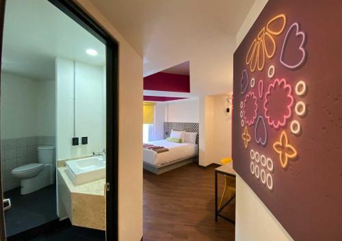 a room with a bathroom with a bed and a mirror at Estancias VIVE MX cuauhtémoc in Mexico City