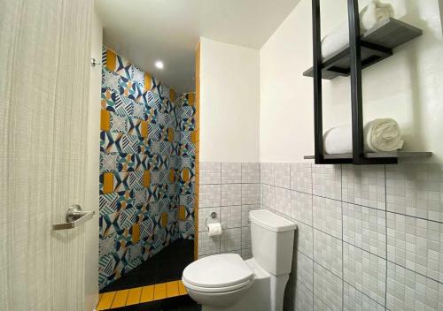 baño con aseo y pared de azulejos en Estancias VIVE MX en Ciudad de México