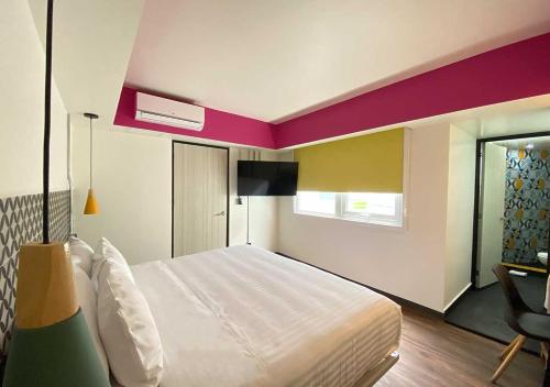 a bedroom with a large white bed in a room at Estancias VIVE MX cuauhtémoc in Mexico City