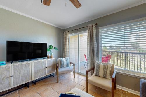 a living room with a large flat screen tv at Marvilla Condo My Happy Place in Galveston