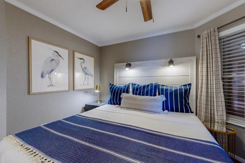 a bedroom with a blue and white bed and a window at Marvilla Condo My Happy Place in Galveston