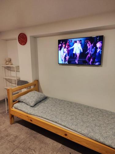 a bedroom with a bed with a television on the wall at Apartment hotels parking akaciju1 in Vilnius