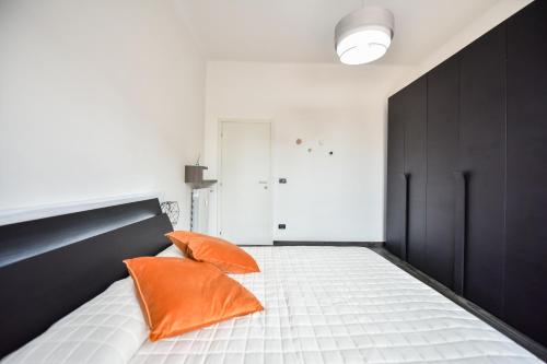 two orange pillows sitting on a bed in a room at Benvenuti Casa Leo - Elegante Appartamento in Turin