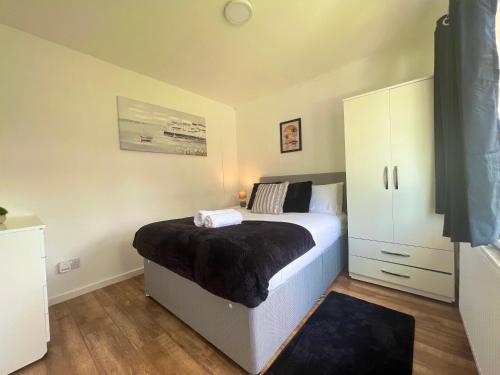 a bedroom with a bed and a white cabinet at The Ultimate Home Away from Home in Birmingham