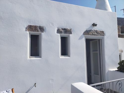 a white building with three windows on it at Amorgos Elegant Houses, 6 Villas in Amorgos