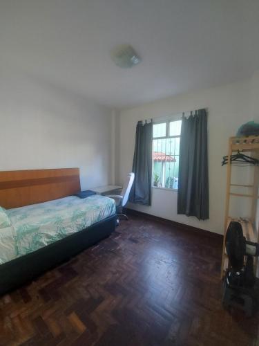 1 dormitorio con cama y ventana en Quarto tranquilo e familiar no leblon - Quiet family room in leblon, en Río de Janeiro
