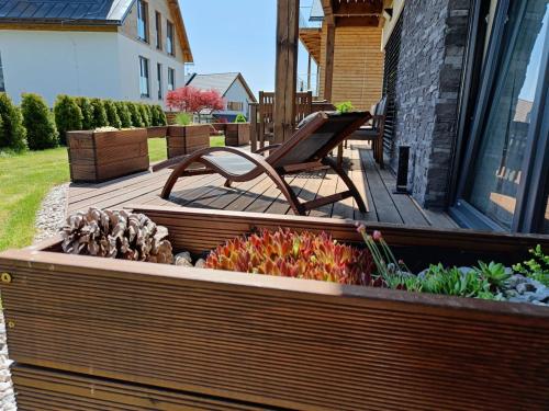 a wooden deck with a bench in a garden at SCANDIC Apartments Boží Dar in Boží Dar