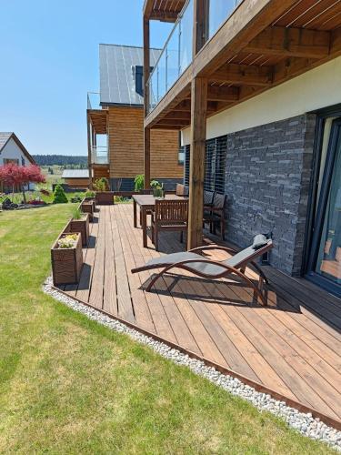 a wooden deck with benches on a house at SCANDIC Apartments Boží Dar in Boží Dar