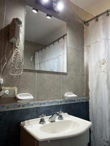 un baño con lavabo y espejo en El Horreo Apart, en Villa Gesell