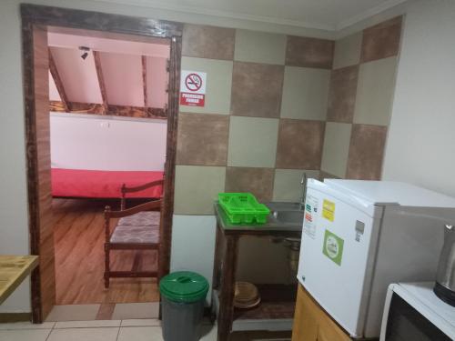 a kitchen with a refrigerator and a table and a room at sleep easy 2 in Coquimbo