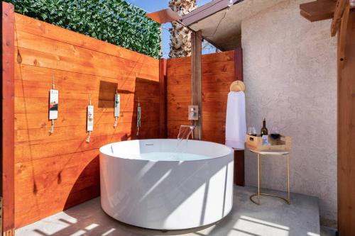 W łazience z drewnianą ścianą znajduje się wanna. w obiekcie Agave Palms Desert Studio, Fire Pit, Soaking Tub w mieście Desert Hot Springs