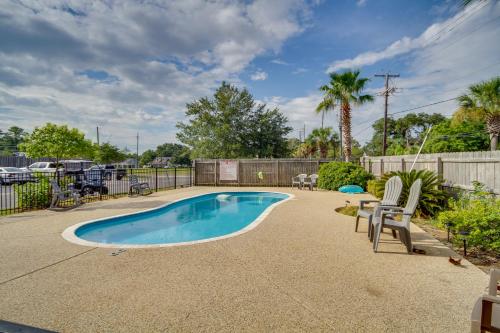 a swimming pool with two chairs and a fence at Cloud 9 on the Gulf, 1 Mi to Beach Pet Friendly in Bay Saint Louis
