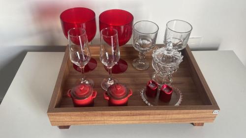 a wooden tray with wine glasses and red wine glasses at One way in João Pessoa