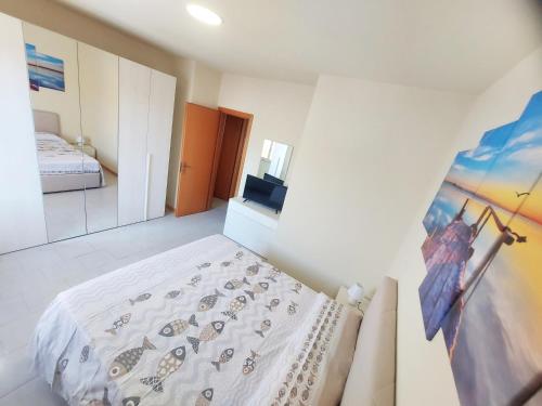 um quarto com uma cama e um quadro na parede em La riva del mare em Santa Teresa di Riva