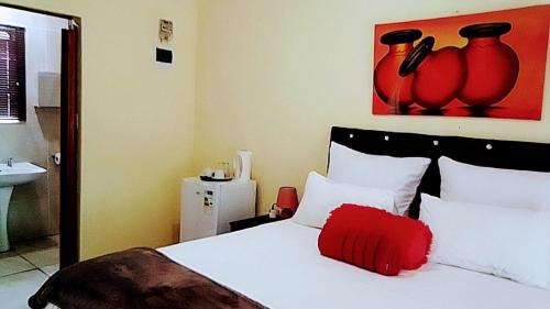 a bedroom with a bed with a red pillow on it at Myto in Newcastle