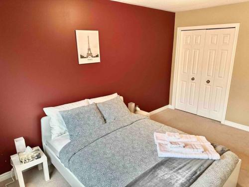 a bedroom with a bed and a red wall at Townhouse in Oakville in Oakville