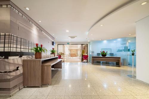 a lobby with a reception desk in a building at Mercure Sao Paulo Moema Times Square in Sao Paulo