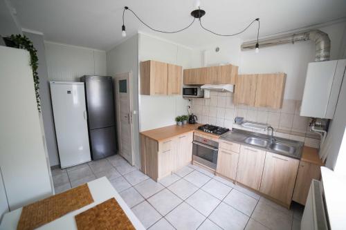una cucina con armadietti in legno ed elettrodomestici in acciaio inossidabile di Pokoje Jaśminowa a Lublino
