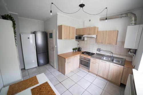 a kitchen with wooden cabinets and stainless steel appliances at Pokoje Jaśminowa in Lublin
