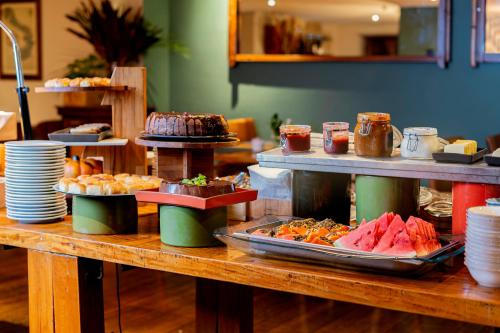 a buffet of food on a wooden table at Mercure Sao Paulo Moema Times Square in Sao Paulo
