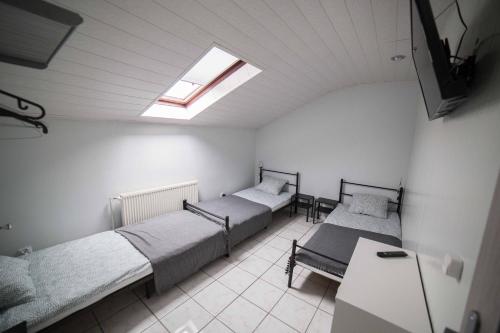 a room with three beds and a skylight at Pokoje Jaśminowa in Lublin